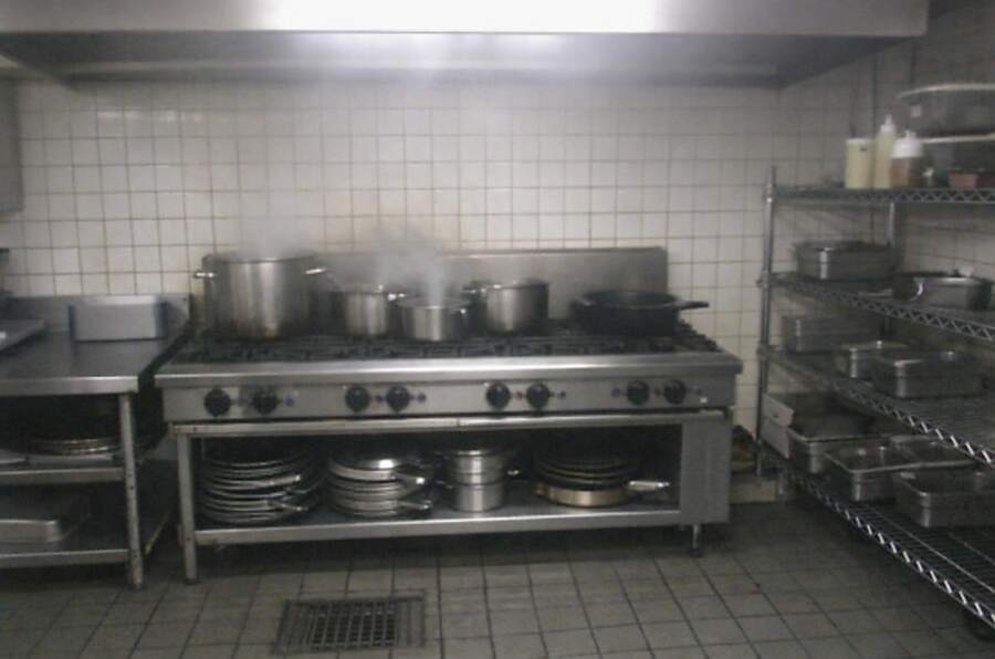 Stainless steel pots on the counter of a restaurant kitchen line