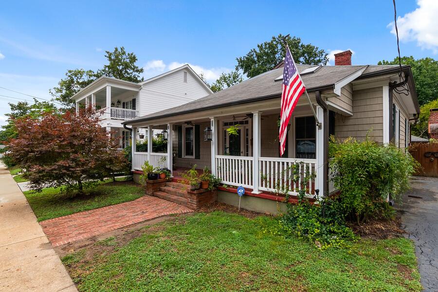 A Craftsman bungalow with a deep front porch and a flag
