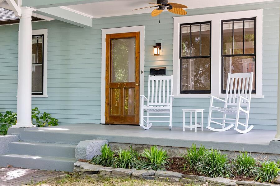 Rocking chairs on the porch of an older wood-frame house
