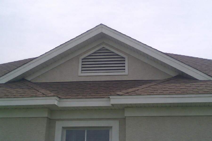 A shingle roofline with a gable vent, the kind of opening a rat uses